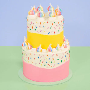 2 Tier Sprinkle Cake from Crumbs & Doilies with colorful sprinkles and rainbow meringue decorations on two buttercream tiers
